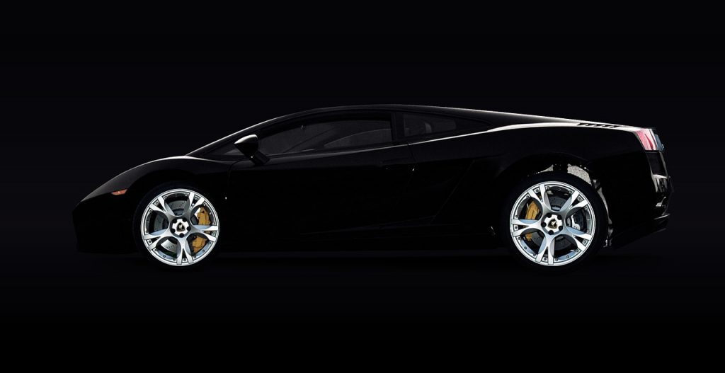 sleek black Lamborghini Gallardo, viewed from the side against a deep black background, emphasizing its aggressive silhouette and high-performance design.