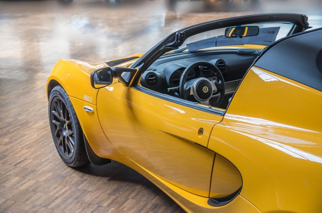 sleek, vibrant yellow Lotus Elise, a compact British sports car known for its lightweight design and sharp handling