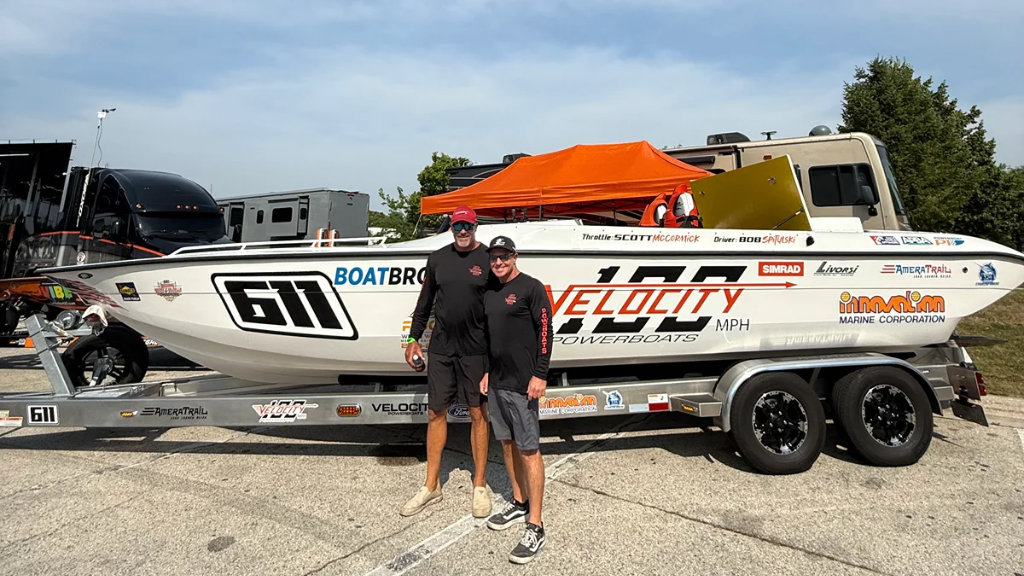 Team Ride Legal's Bob Spitulski and Scott McCormick standing proudly in front of their Velocity offshore racing boat (number 611) on its trailer at a race event.